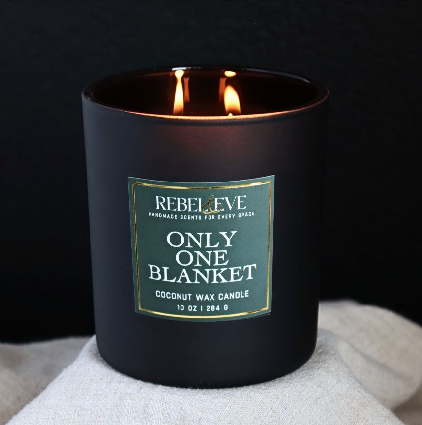Black Only One Blanket candle with a label on a dark background